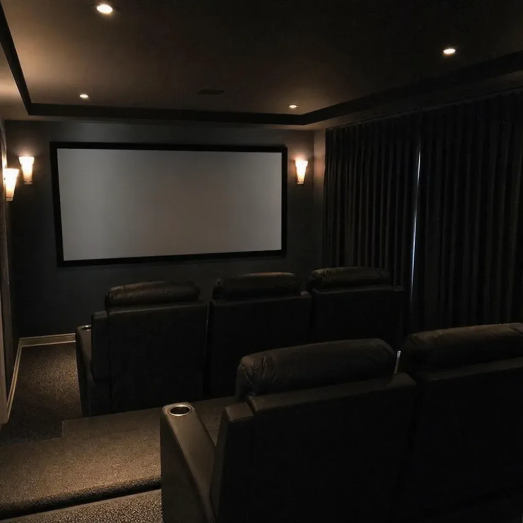 Dark colored home theater room with thick blackout curtains over the windows