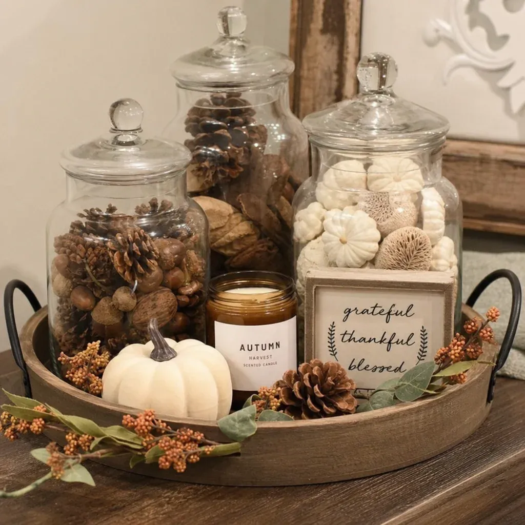 A beautifully arranged tray with apothecary jars and seasonal decor elements